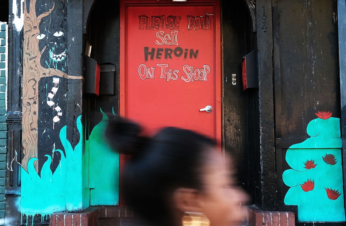 A door is painted with the message to stop selling heroin on a street in a neighborhood in New York City.