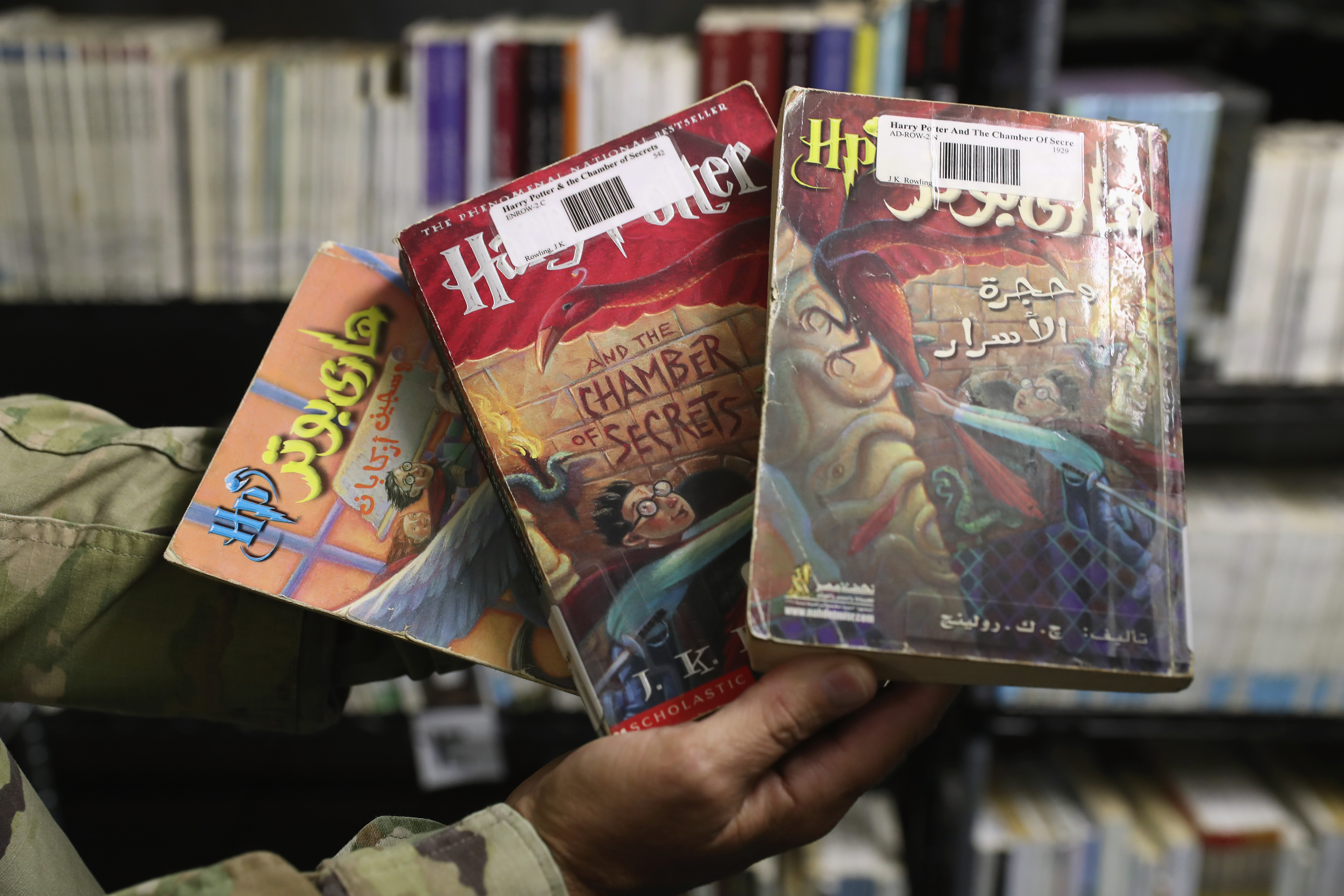 A military officer displays copies of Harry Potter books in Arabic and English at in the library of the Guantanamo Bay Detention Center on October 22nd, 2016.