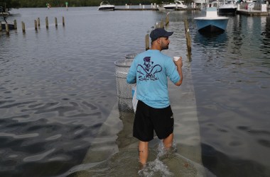 A man walks through a king tide flood in South Florida.