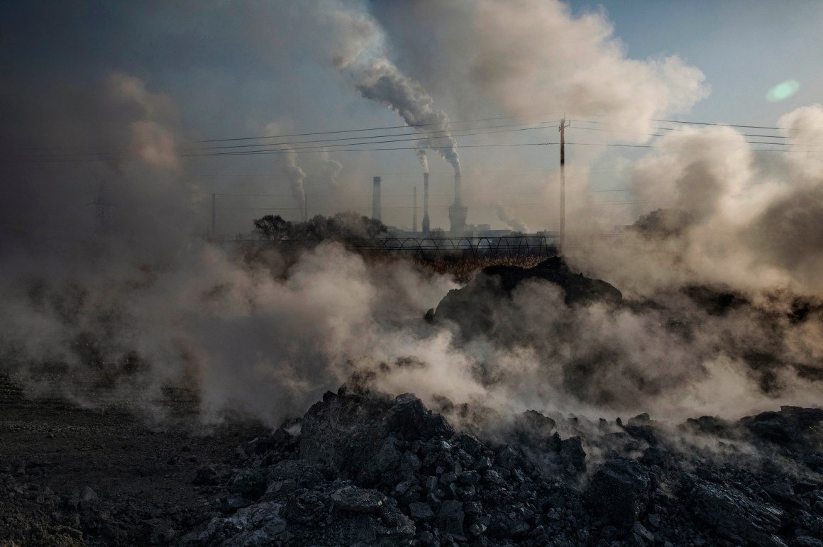 Steam and smoke from waste coal and stone rises after being dumped next to an unauthorized steel factory.