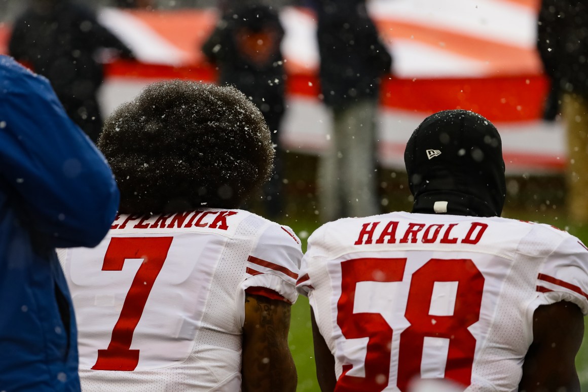 Colin Kaepernick and Eli Harold of the San Francisco 49ers kneel for the national anthem at Soldier Field in Chicago, Illinois, on December 4th, 2016.