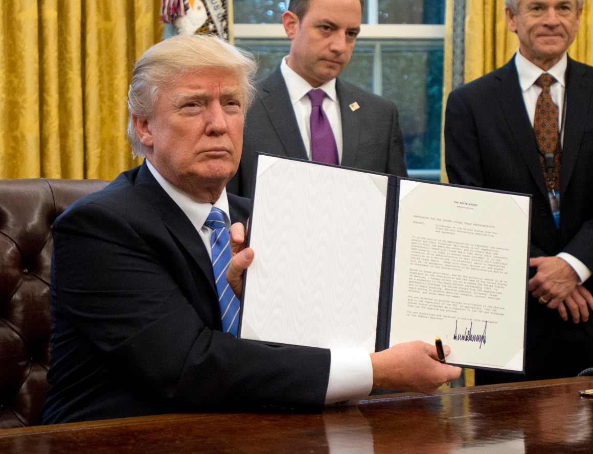 President Donald Trump shows the executive order withdrawing the U.S. from the Trans-Pacific Partnership after signing it in the Oval Office of the White House.