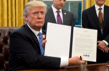 President Donald Trump shows the executive order withdrawing the U.S. from the Trans-Pacific Partnership after signing it in the Oval Office of the White House.