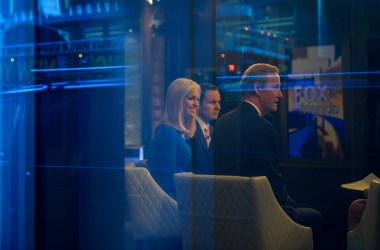 Seen through a window, (from left) hosts Ainsley Earhardt, Brian Kilmeade, and Steve Doocy broadcast Fox and Friends from the Fox News studios on February 17th, 2017, in New York City.