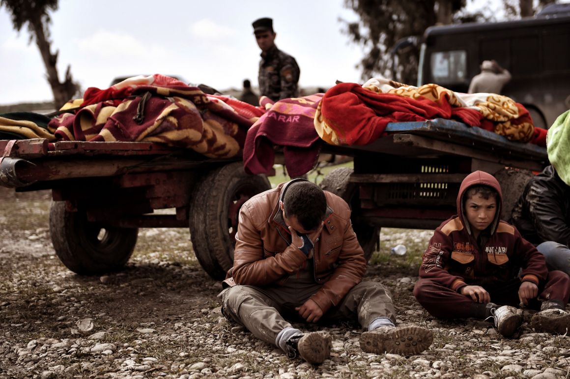 Relatives mourn as bodies of Iraqi residents of west Mosul killed in an airstrike are placed and covered with blankets on carts on March 17th, 2017.