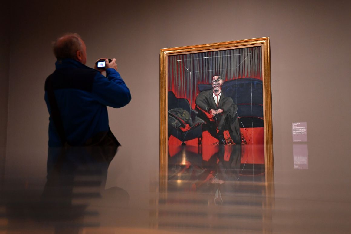 A man takes a photograph of Seated Figure, 1961, an oil painting by Irish-born British artist Francis Bacon, as part of the Queer British Art 1861-1967 exhibition at the Tate Britain in London on April 3rd, 2017.