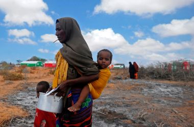 Newly displaced Somali women and children walk to a food distribution center at the Kaxda district on the outskirts of Mogadishu on April 9th, 2017.