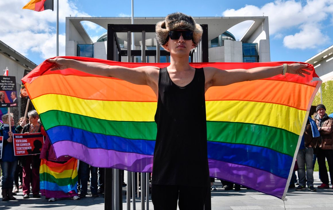 An activist displays a rainbow flag in front of the Chancellery in Berlin on April 30th, 2017, during a demonstration calling for an end to the persecution of gay men in Chechnya.