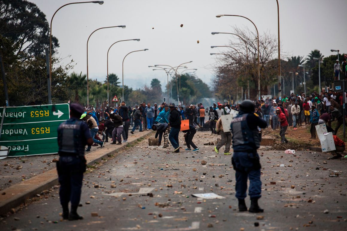 Residents throw stones during clashes with riot police in Johannesburg, South Africa, on May 8th, 2017, following a demonstration over land grabbing, housing, and unemployment in the area.