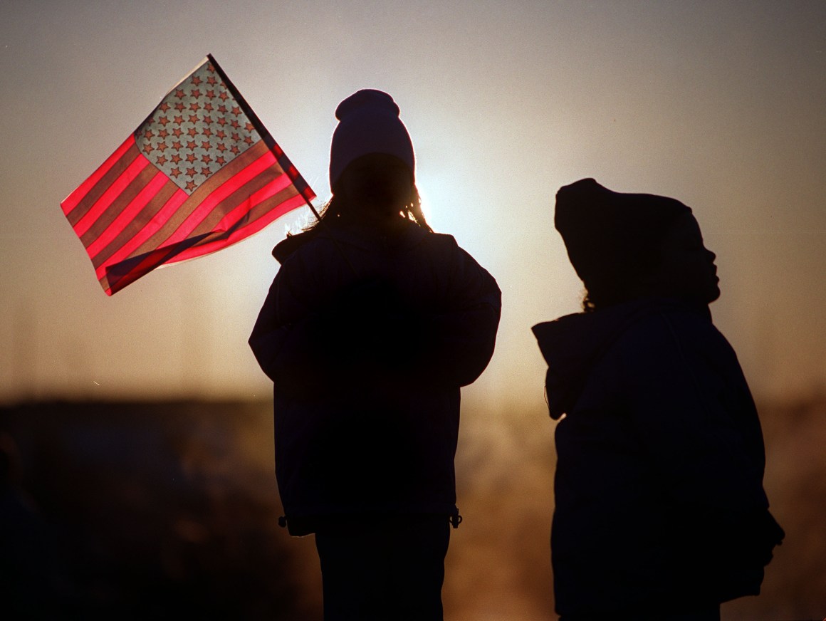 Eight-year-old Julie Jackson (left) and her three-year-old sister, Melissa Jackson, brave the early morning cold as they wait for the arrival of their father on the aircraft carrier USS Enterprise to Naval Station Norfolk November 10th, 2001, in Norfolk, Virginia.