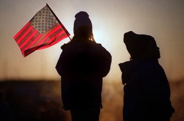 Eight-year-old Julie Jackson (left) and her three-year-old sister, Melissa Jackson, brave the early morning cold as they wait for the arrival of their father on the aircraft carrier USS Enterprise to Naval Station Norfolk November 10th, 2001, in Norfolk, Virginia.