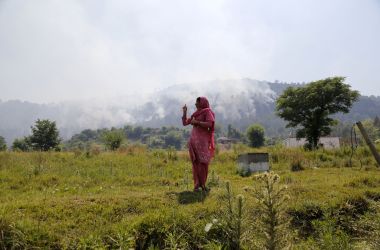 An Indian resident gestures toward rising smoke, believed to have resulted from mortar shelling, in the village of Jhangar, which lies very close to Pakistan on the Line of Control, on May 14th, 2017.