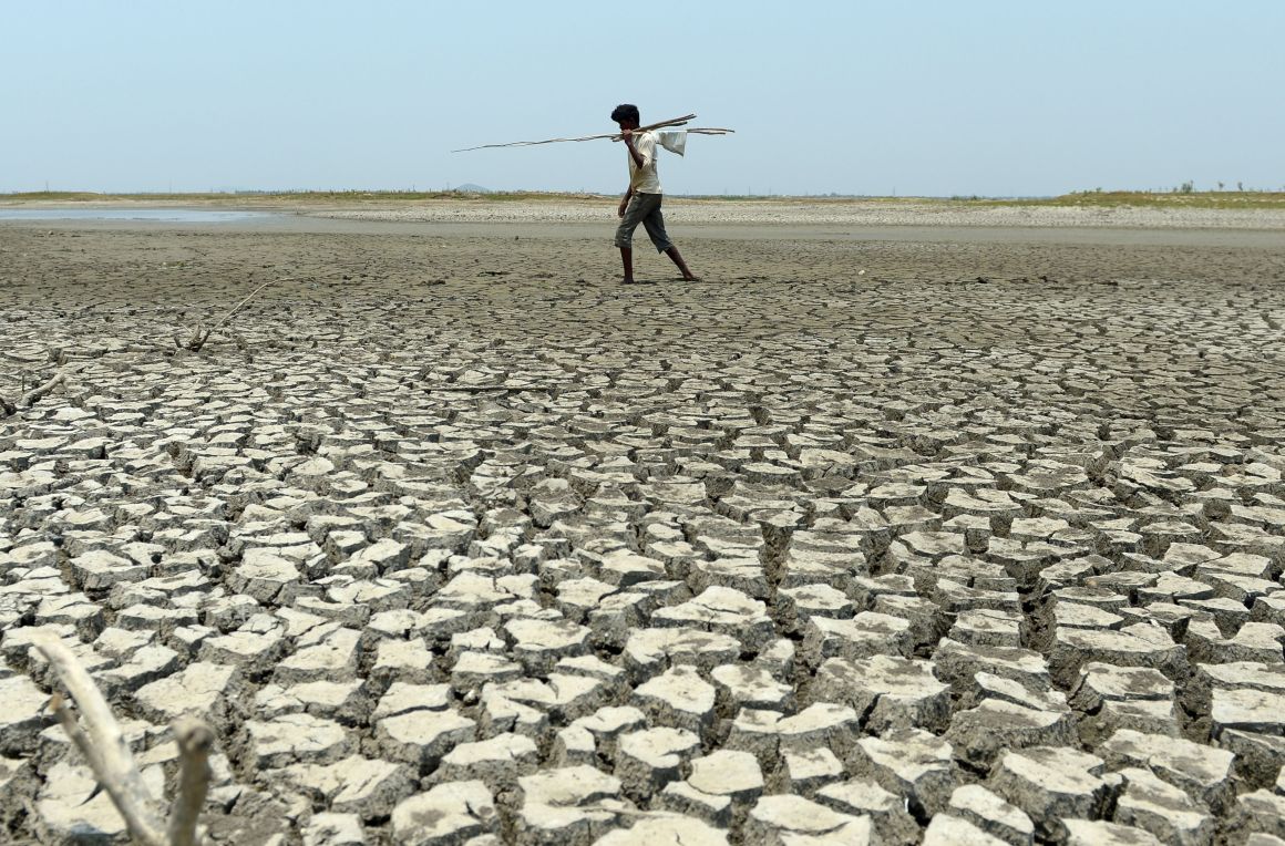 An Indian man walks over the parched bed of a reservoir on the outskirts of Chennai on May 17th, 2017.