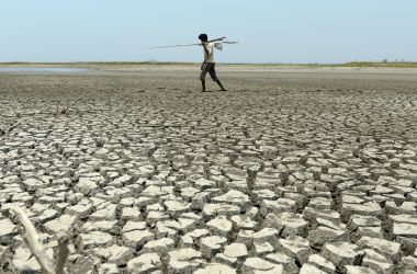 An Indian man walks over the parched bed of a reservoir on the outskirts of Chennai on May 17th, 2017.