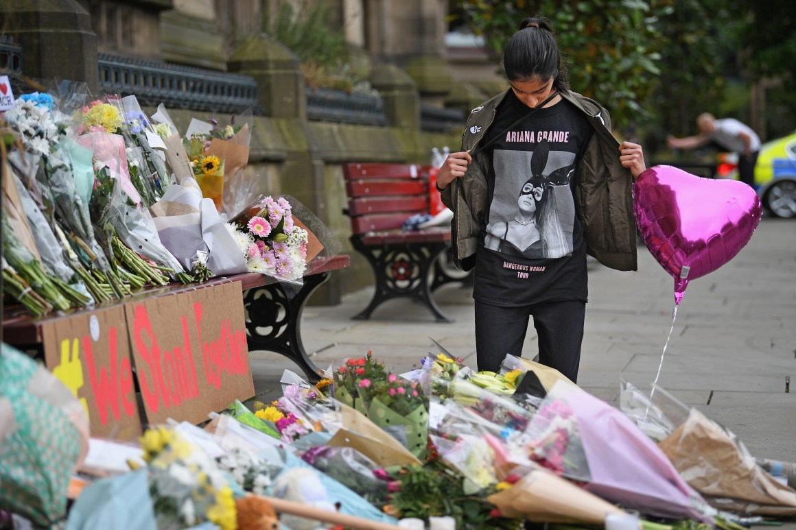 A 13-year-old girl who attended the Ariana Grande concert looks at floral tributes and messages in Manchester, England, on May 24th, 2017.