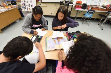 Students work on a project identifying countries in North, Central, and South America during a history class.