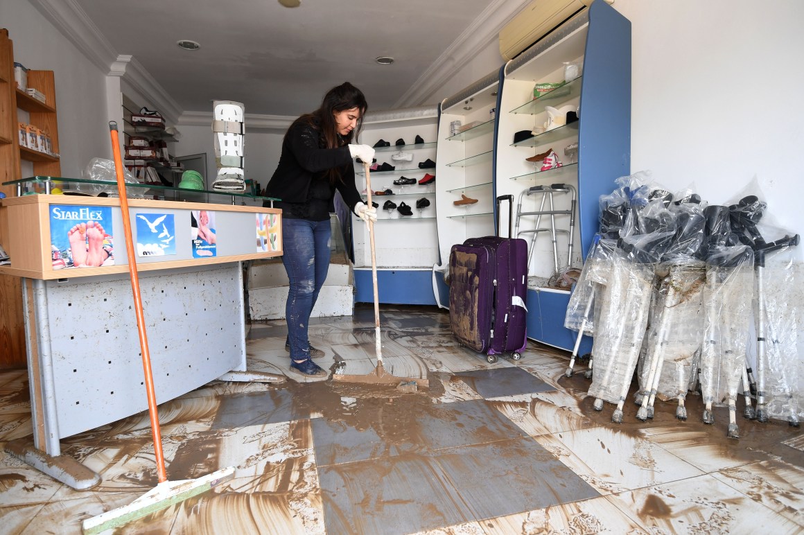 A Tunisian woman cleans her orthopedic shop in Manouba on June 6th, 2017, following a storm the previous night.