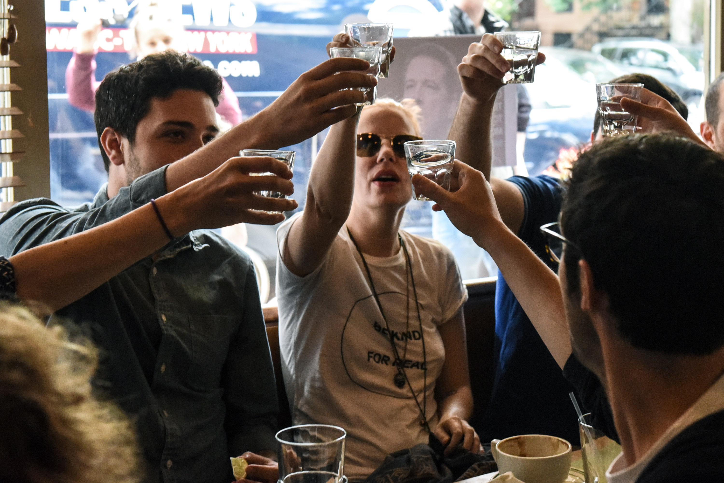 People drink while watching former FBI Director James Comey's testimony on June 8th, 2017, in Brooklyn, New York City.