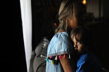 An undocumented woman from Peru holds her one-year-old son at their home in Thornton, Colorado.