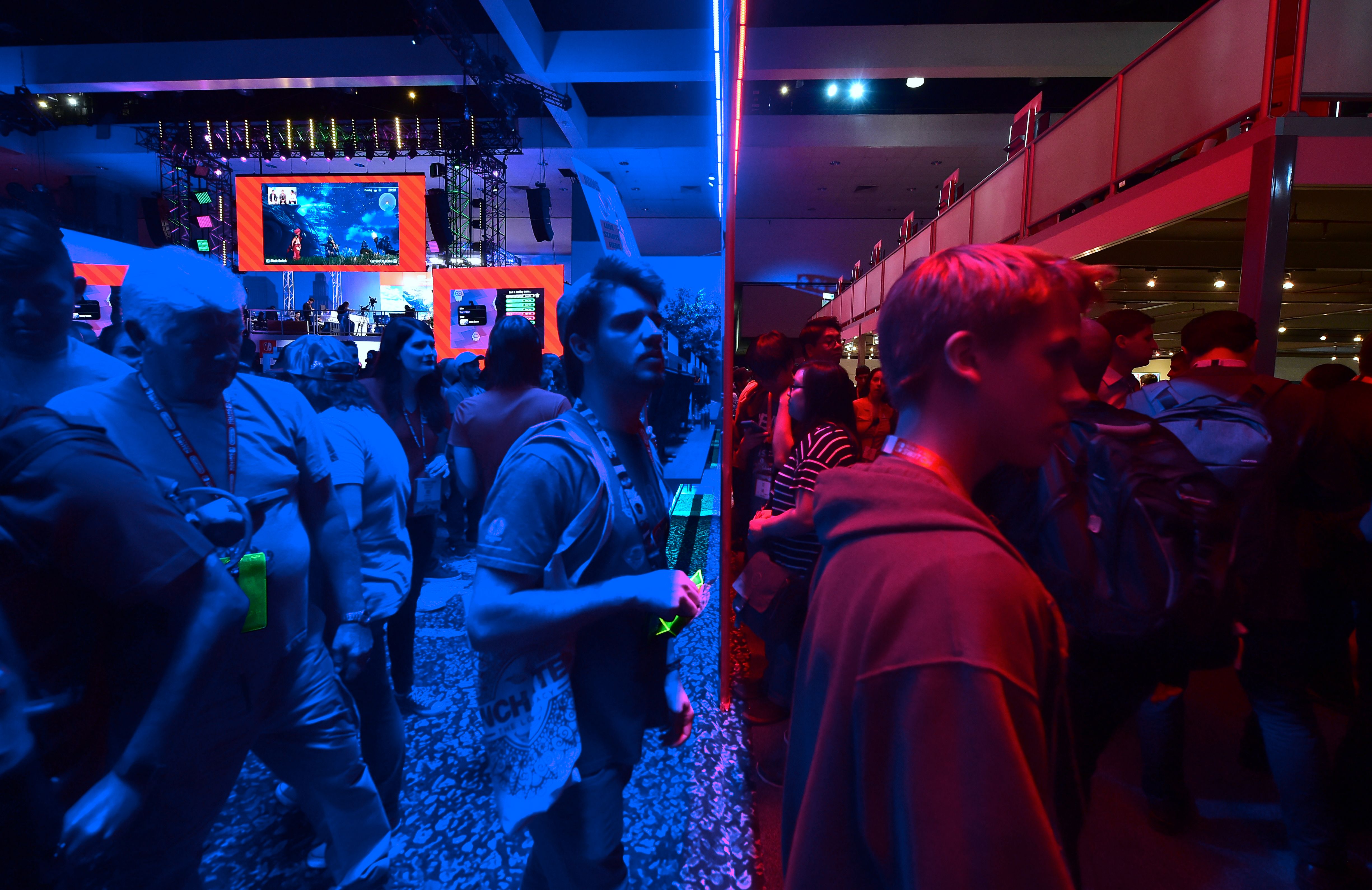 Gaming fans step from the Playstation blue into the Nintendo red display rooms on day one of E3 2017, the three-day Electronic Entertainment Expo, one of the biggest events in the gaming industry calendar, on June 13th, 2017 in Los Angeles, California.