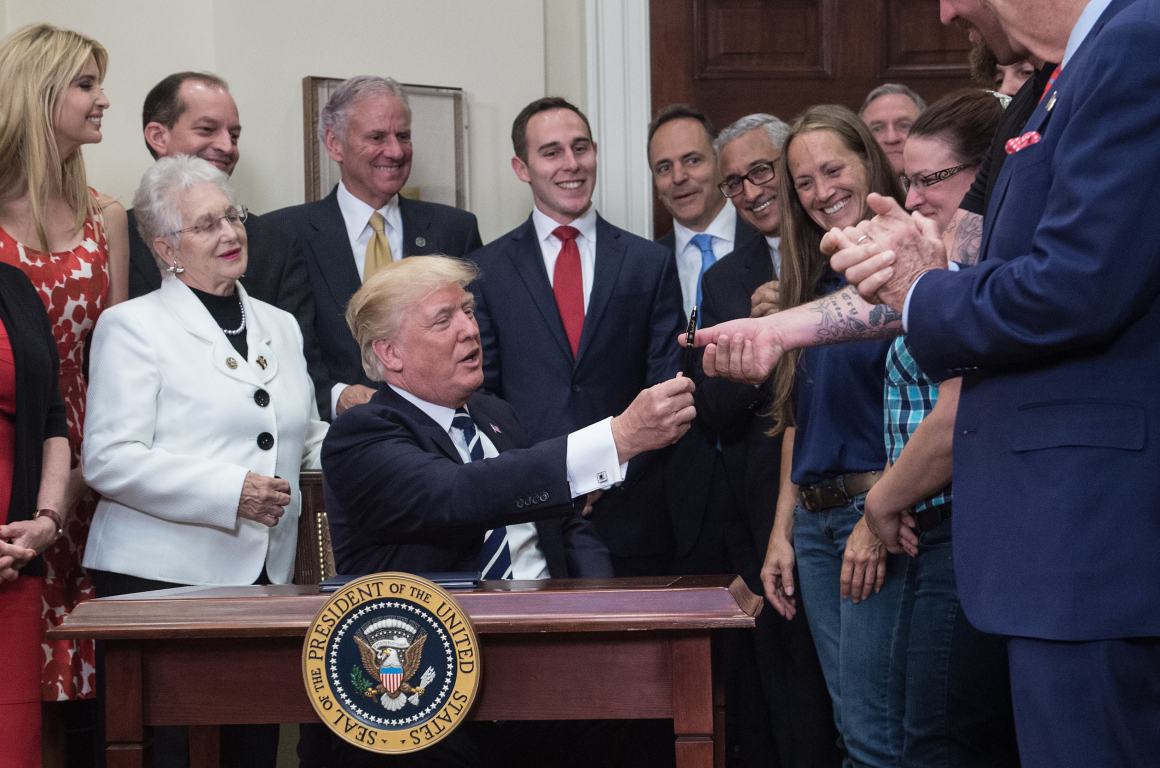 President Donald Trump hands over the pen he used to sign an executive order on the Apprenticeship and Workforce of Tomorrow initiatives on June 15th, 2017.