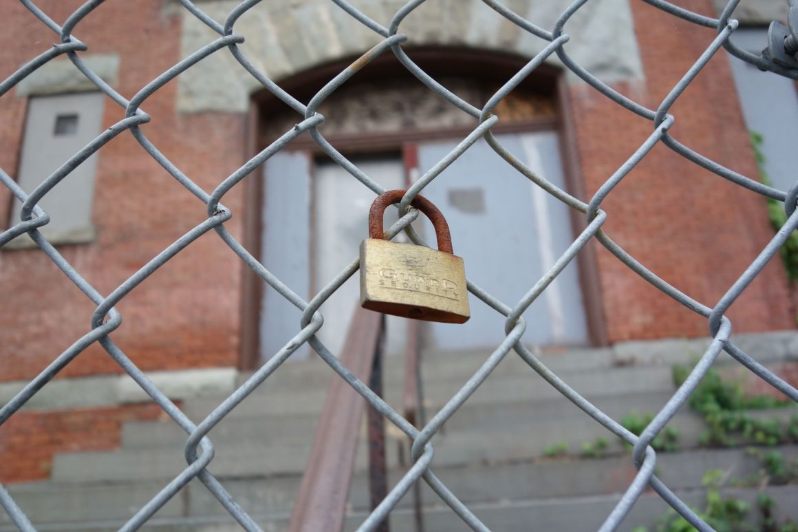 A padlock hangs outside a shuttered schoolhouse in New York.