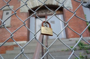 A padlock hangs outside a shuttered schoolhouse in New York.