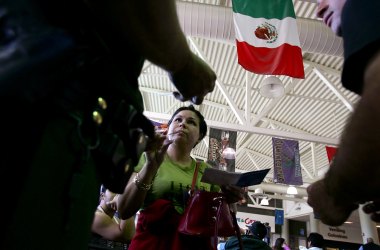 Members of the United States Border Patrol check a woman's identification at a Greyhound bus station in Phoenix, Arizona.