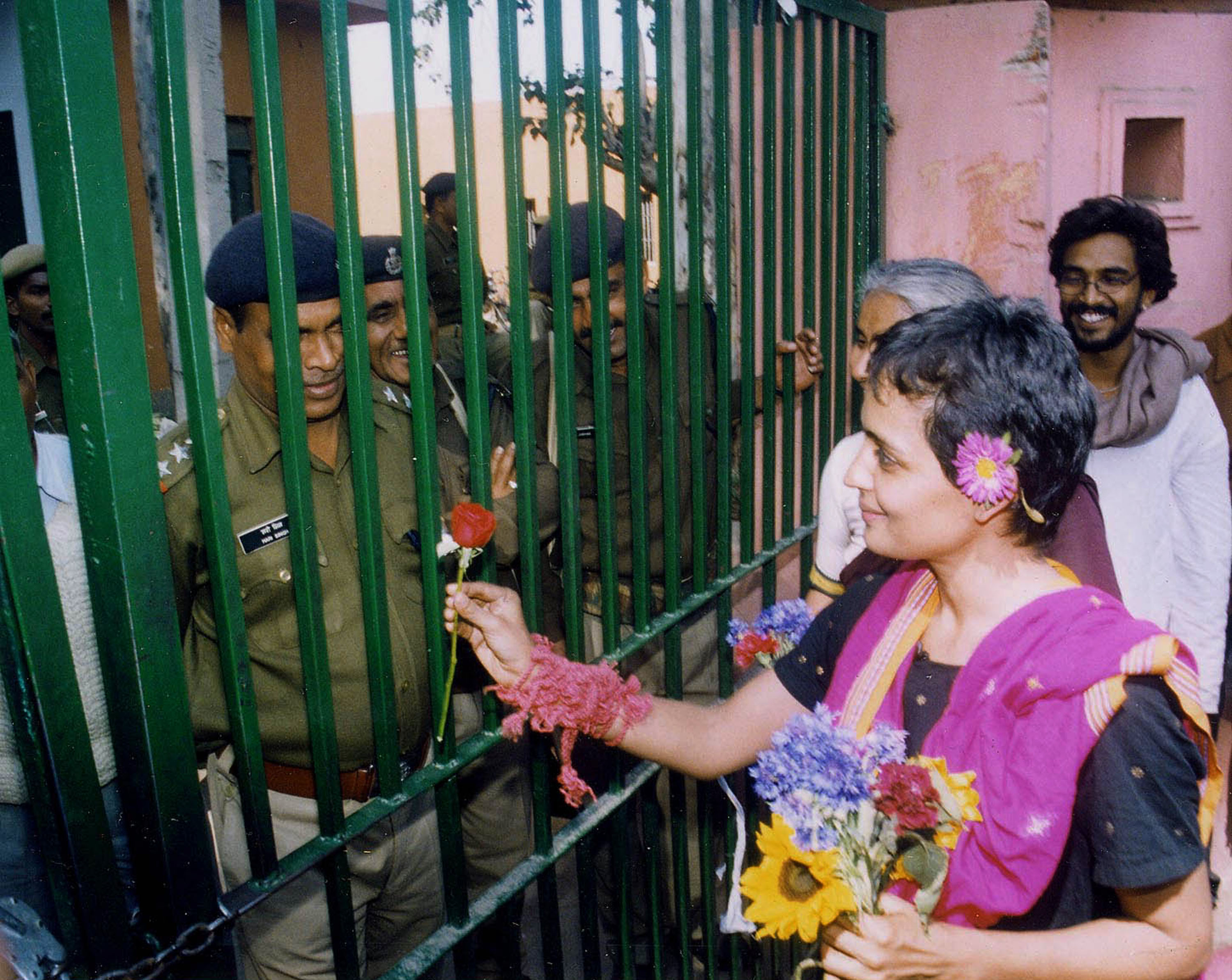 Arundhati Roy presents a flower to the jail guards as she leaves the Tihar Central Jail after serving a short sentence for contempt of court in New Delhi, India, on March 7th, 2002.