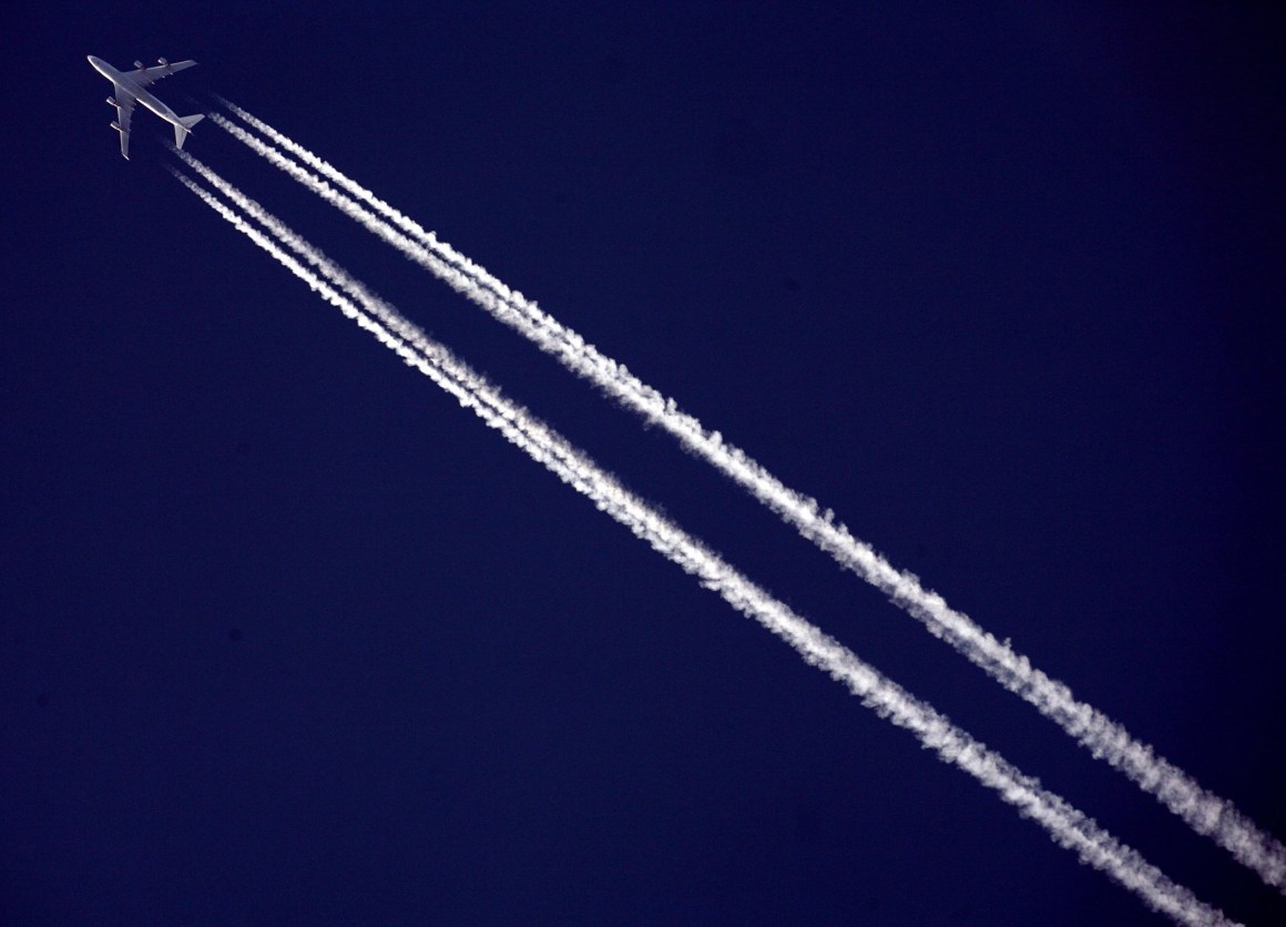 A commercial airliner flies across the sky.