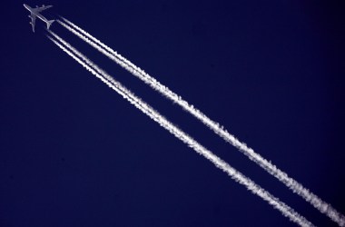 A commercial airliner flies across the sky.