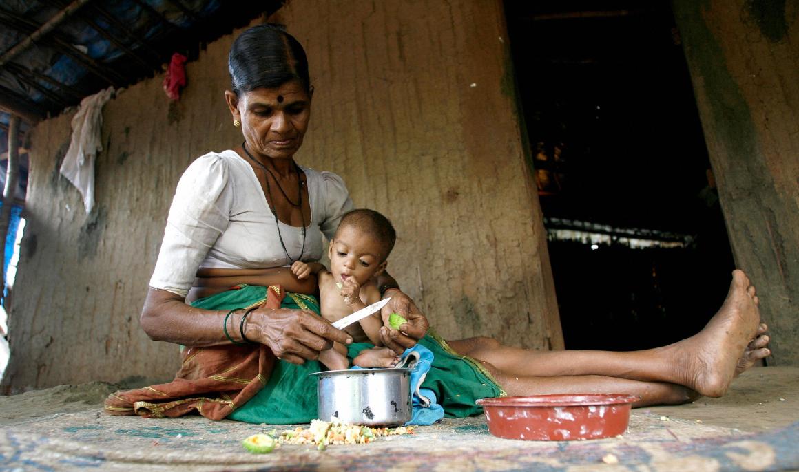 Hira Bai takes care of her grandchild Rohit in their mud and bamboo reinforced hut in Devipada, a tribal settlement in the remote forestland of Aarey Milk Colony on the outskirts of Mumbai.