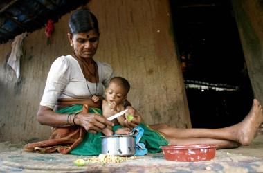 Hira Bai takes care of her grandchild Rohit in their mud and bamboo reinforced hut in Devipada, a tribal settlement in the remote forestland of Aarey Milk Colony on the outskirts of Mumbai.