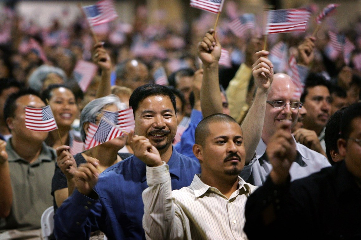 Immigrants wave flags after being sworn in as U.S. citizens in naturalization ceremonies on July 26th, 2007, in Pomona, California.