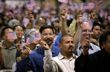 Immigrants wave flags after being sworn in as U.S. citizens in naturalization ceremonies on July 26th, 2007, in Pomona, California.