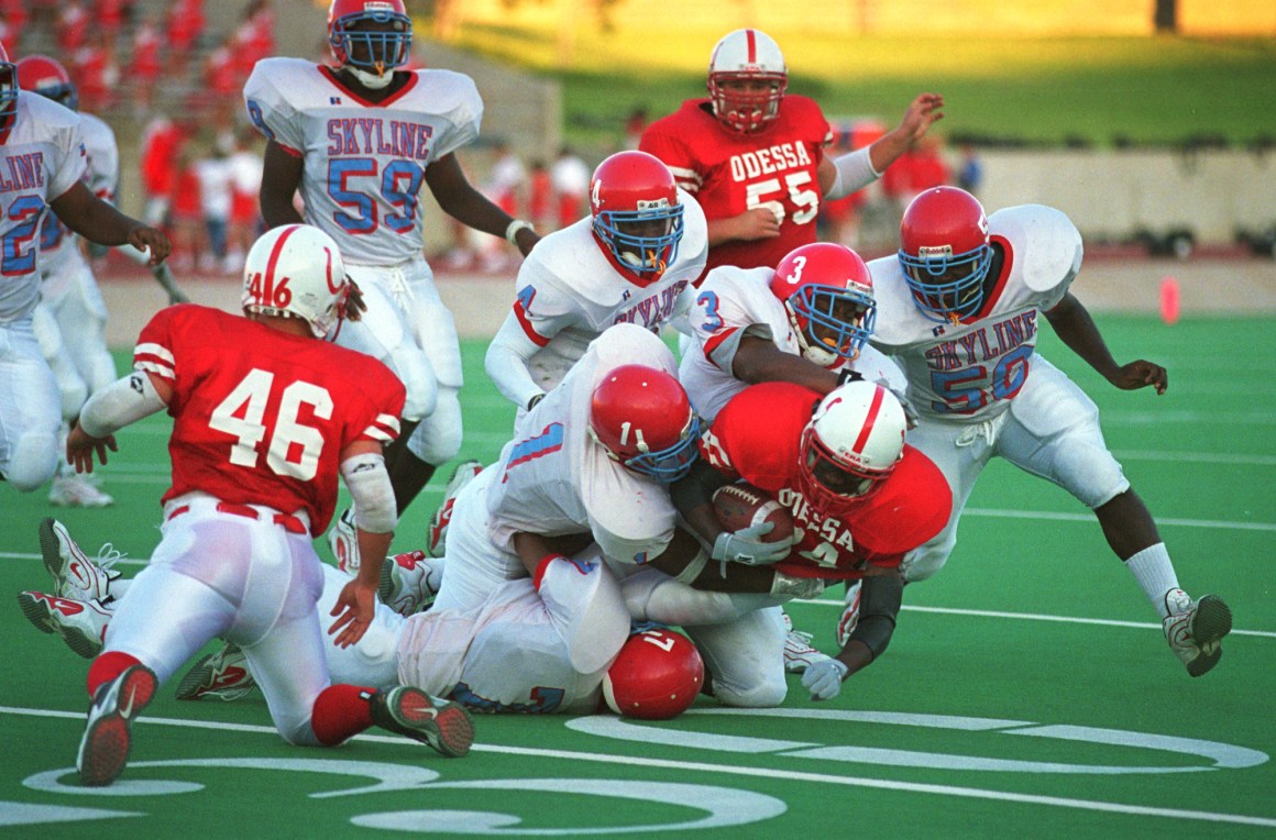 Football players from Odessa High School and Dallas Skyline High School play on September 1st, 2000, in Odessa, Texas.