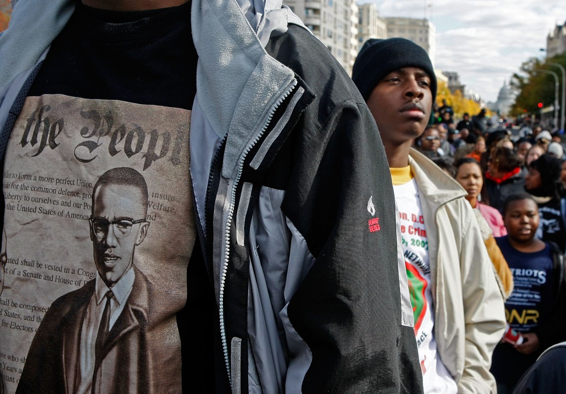 Lloyd Marshall (L) wears a Malcolm X shirt while participating in a march around the Department of Justice to protest hate crimes on November 16th, 2007, in Washington, D.C.