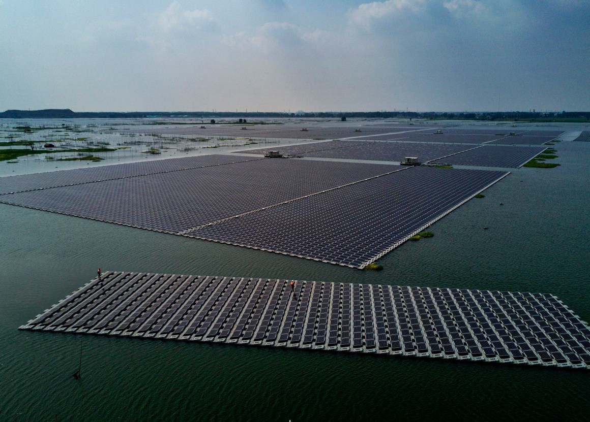 A boat tows a group of solar panels before they are connected to a large floating solar farm project on June 14th, 2017, in Huainan, Anhui province, China.