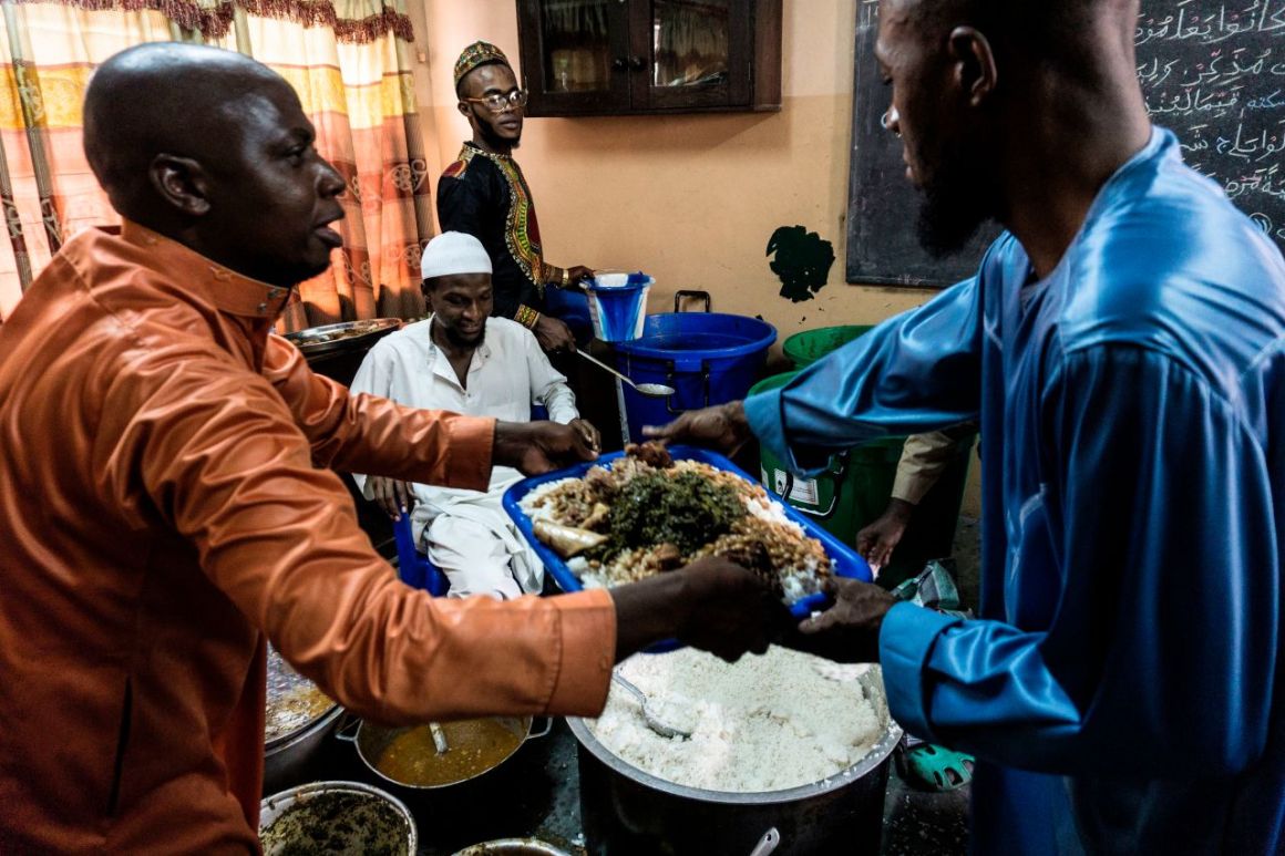 People distribute food to fellow Muslim worshippers before breaking the Ramadan fast on June 25th, 2017, in Kinshasa, Democratic Republic of the Congo.