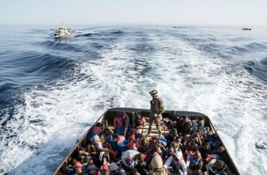 A Libyan coast guardsman stands on a boat during the rescue of 147 undocumented immigrants attempting to reach Europe off the coastal town of Zawiyah, 45 kilometers west of the capital Tripoli, on June 27th, 2017. More than 8,000 migrants have been rescued in waters off Libya during the past 48 hours in difficult weather conditions, Italy's coastguard said.