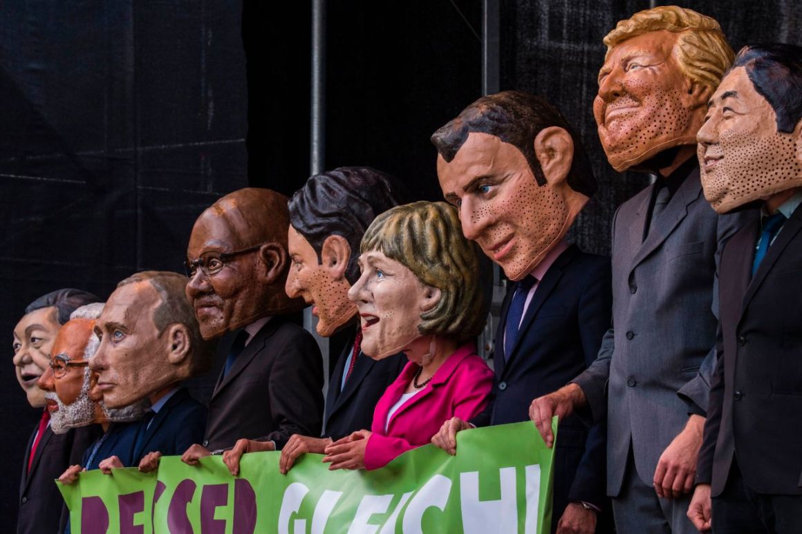 Performers wearing masks of world leaders hold a placard reading "Better Off Equal! Close the Gap Between Rich and Poor" during a demonstration called by several non-governmental organizations ahead of the G20 summit in Hamburg on July 2nd, 2017.