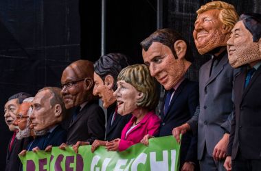 Performers wearing masks of world leaders hold a placard reading "Better Off Equal! Close the Gap Between Rich and Poor" during a demonstration called by several non-governmental organizations ahead of the G20 summit in Hamburg on July 2nd, 2017.