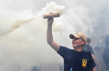 An activist holds up a flare during a protest in front of Ukrainian Parliament in Kiev on July 11th, 2017, demanding the removal of immunity for deputies. The parliament of Ukraine is debating the submission by the general prosecutor's office on the removal of parliamentary immunity from five parliamentarians suspected of corruption.