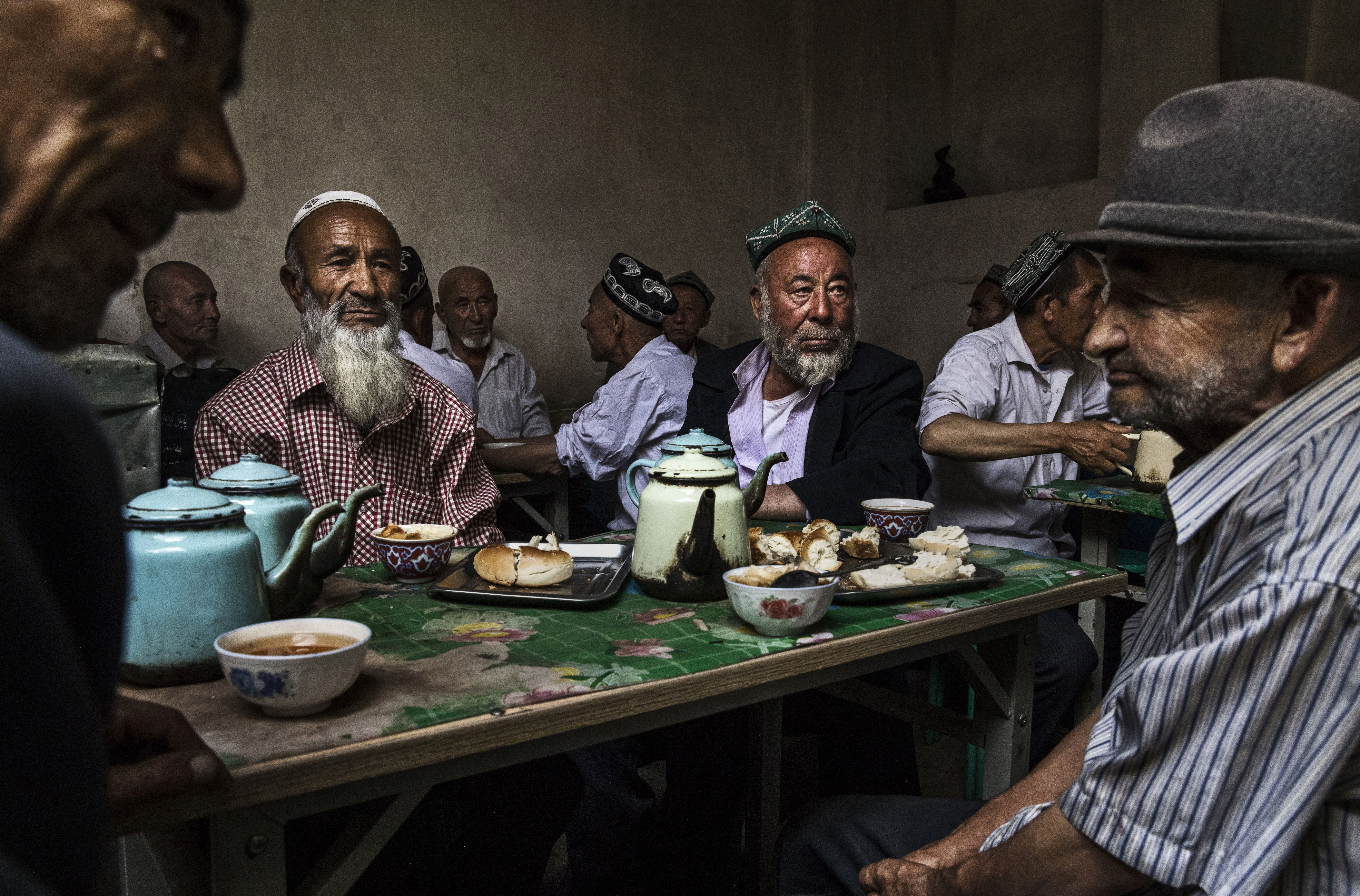 Uyghur men talk at a teahouse in the old town of Kashgar in Xinjiang province, China, on July 1st, 2017. Kashgar has long been considered the cultural heart of Xinjiang for the province's nearly 10 million Muslim Uyghurs.