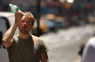 A man tries to cool himself with a bottle of water during a heat wave on June 9th, 2008, in New York City.