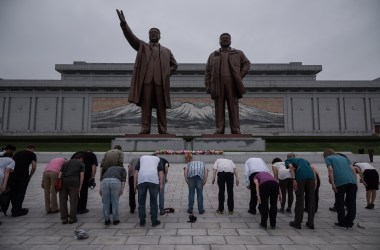 A group of tourists bow before statues of late North Korean leaders Kim Il-Sung (left) and Kim Jong-Il in Pyongyang on July 23rd, 2017.