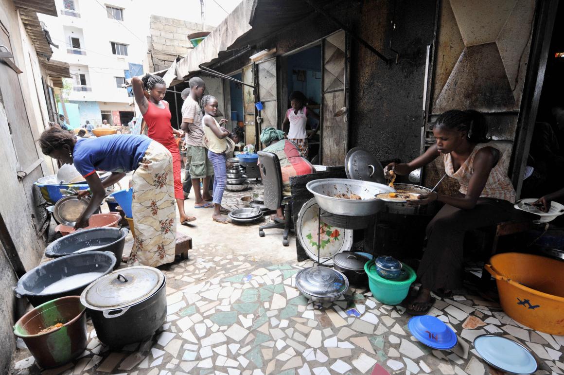 A woman prepares rice and fish at her street restaurant in Dakar, Senegal.