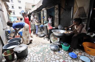 A woman prepares rice and fish at her street restaurant in Dakar, Senegal.