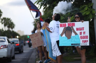 Protesters hold signs during a People for Peace Rally at the Chief Quipuha Statue on August 14th, 2017, in Hagatna, Guam.