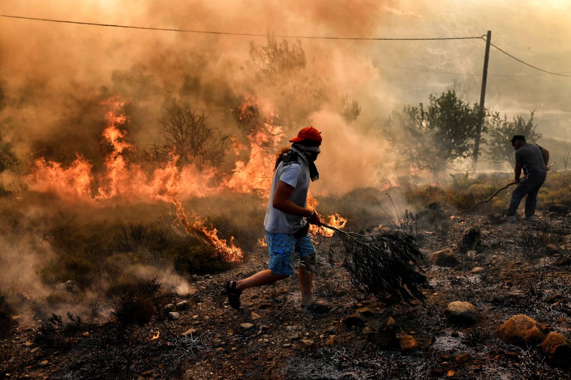 A man runs away from flames as fire burns the land, east of the Greek capital of Athens on August 15th, 2017. The army was called in to assist firefighters around Kalamos, 30 miles east of Athens, where a fire has been burning since August 13th. In all, 146 fires have broken out across Greece since then, according to authorities.